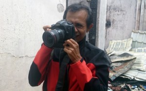 Bedu Saini saat menjalankan tugas jurnalistik. | FOTO: Nurdin Hasan/ACEHKITA.COM